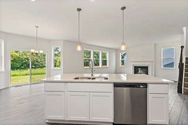 a kitchen with a sink stove and wooden floor