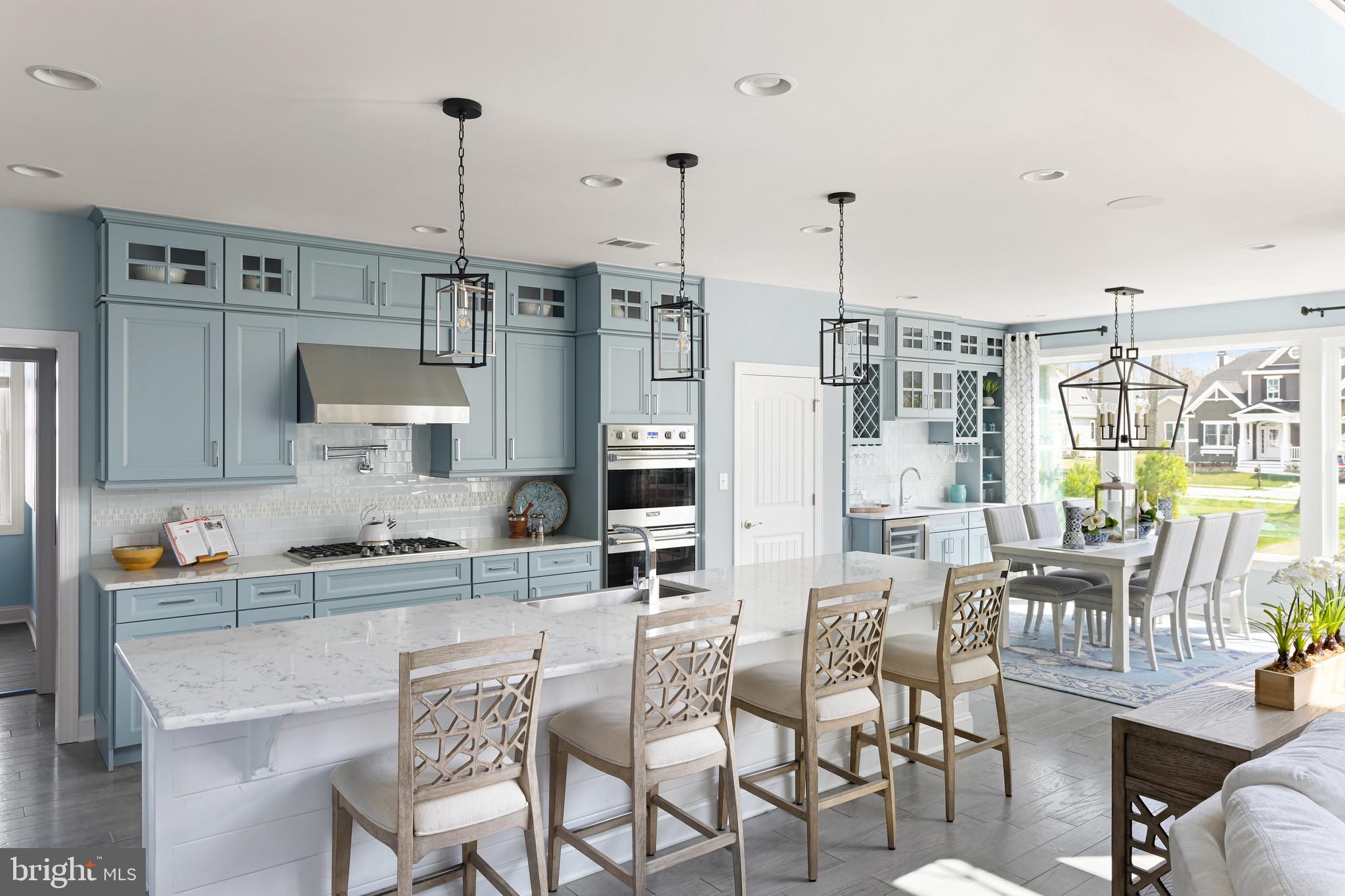 21826 Eastbridge Loop Lewes, DE 19958 - Photo 14 of 27 a dining hall with stainless steel appliances kitchen island granite countertop a dining table chairs and a kitchen view