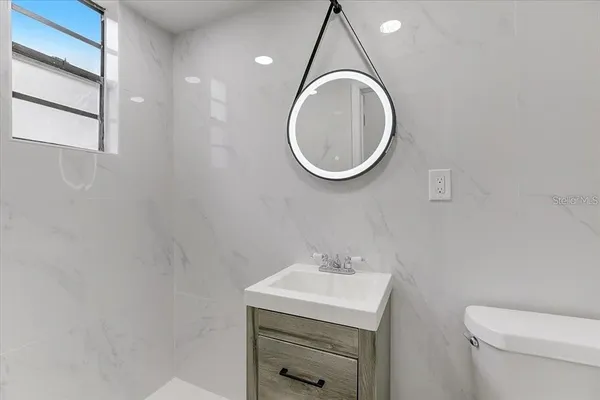 a bathroom with a sink a toilet and a mirror