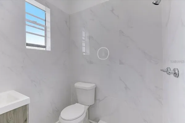 a white toilet sitting next to a window