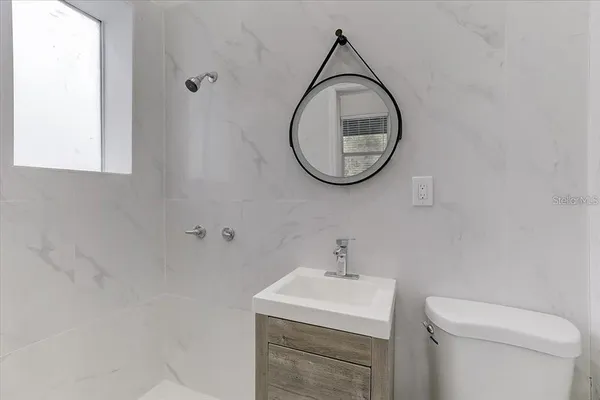 a bathroom with a toilet a sink and a mirror