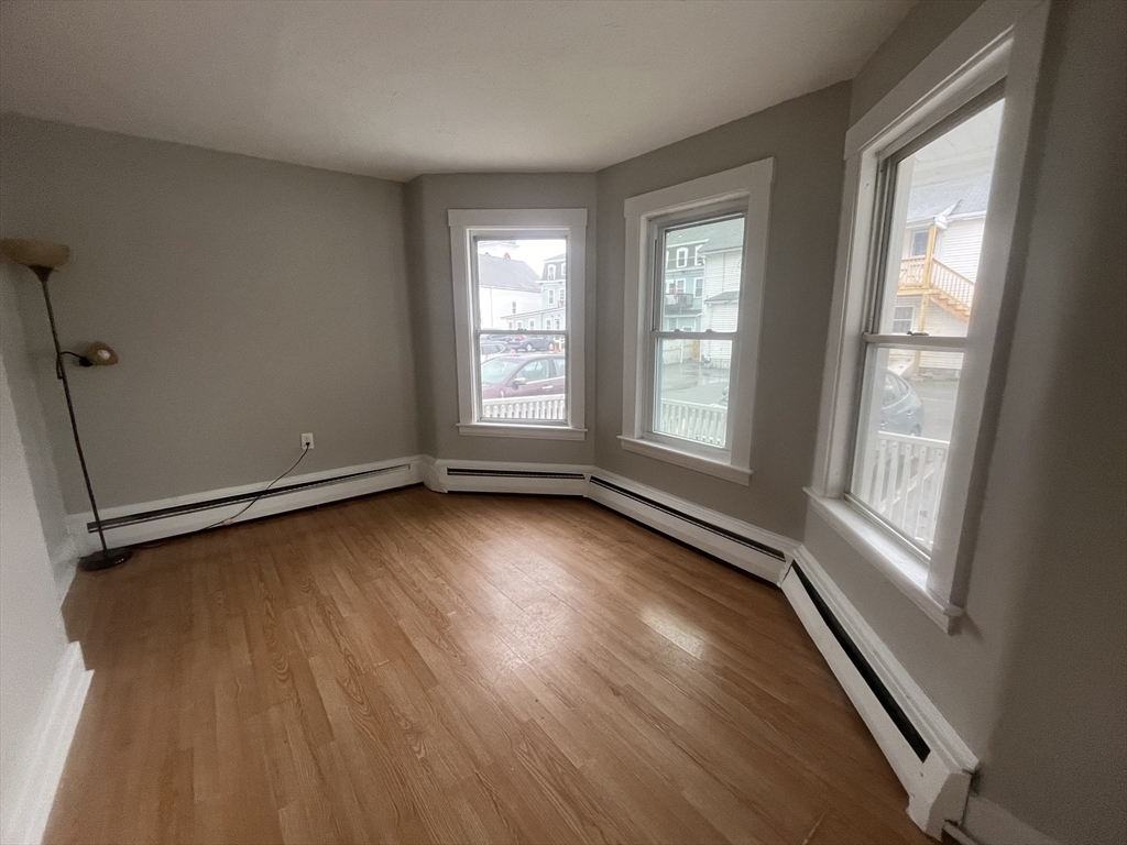 349 Main Street, Unit 2 Douglas, MA 01516 - Photo 6 of 11 an empty room with wooden floor and windows