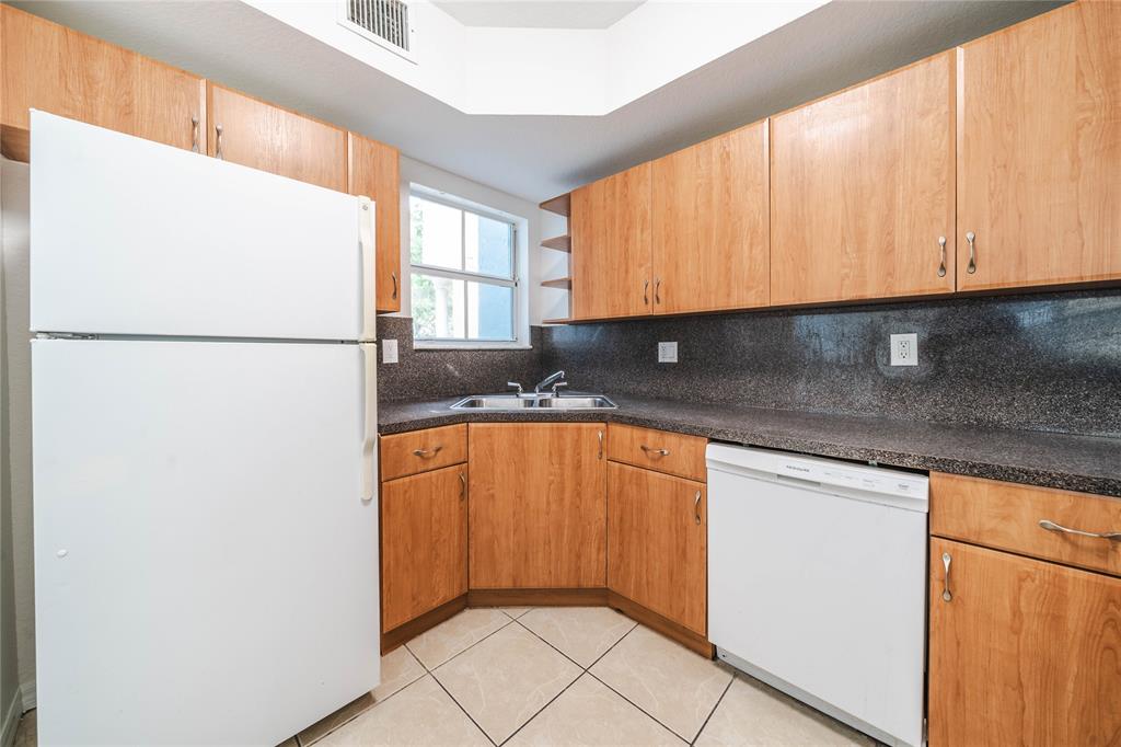 845 Southwest 6th Court Homestead, FL 33034 - Photo 11 of 30 a kitchen with stainless steel appliances granite countertop a refrigerator a sink and a stove