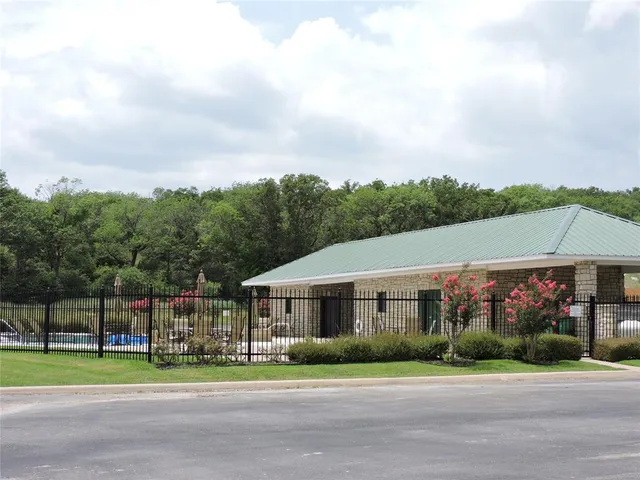 a aerial view of a house with a yard and table and chairs under an umbrella