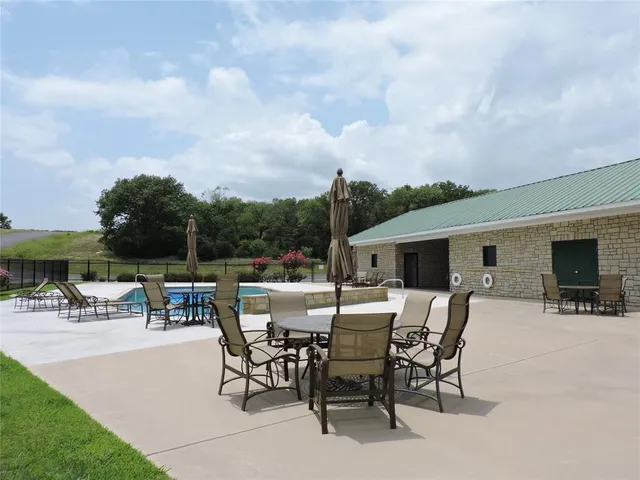 a view of a patio with a table and chairs under an umbrella