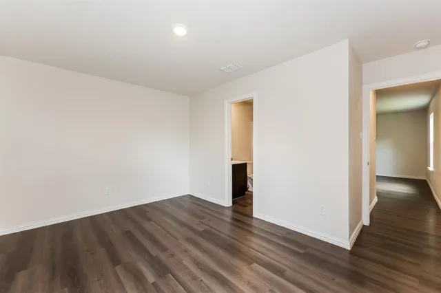 an empty room with wooden floor and a window
