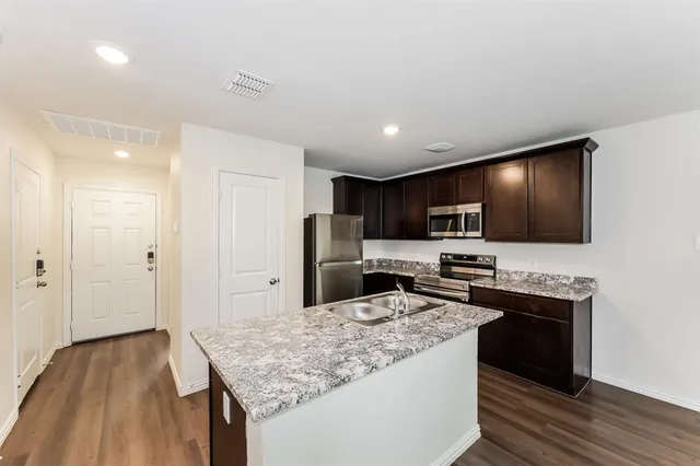 a view of kitchen with wooden floor and electronic appliances