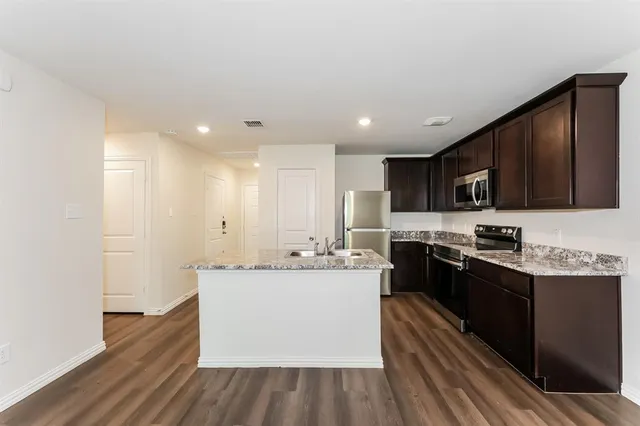 a kitchen with stainless steel appliances granite countertop a sink stove and refrigerator