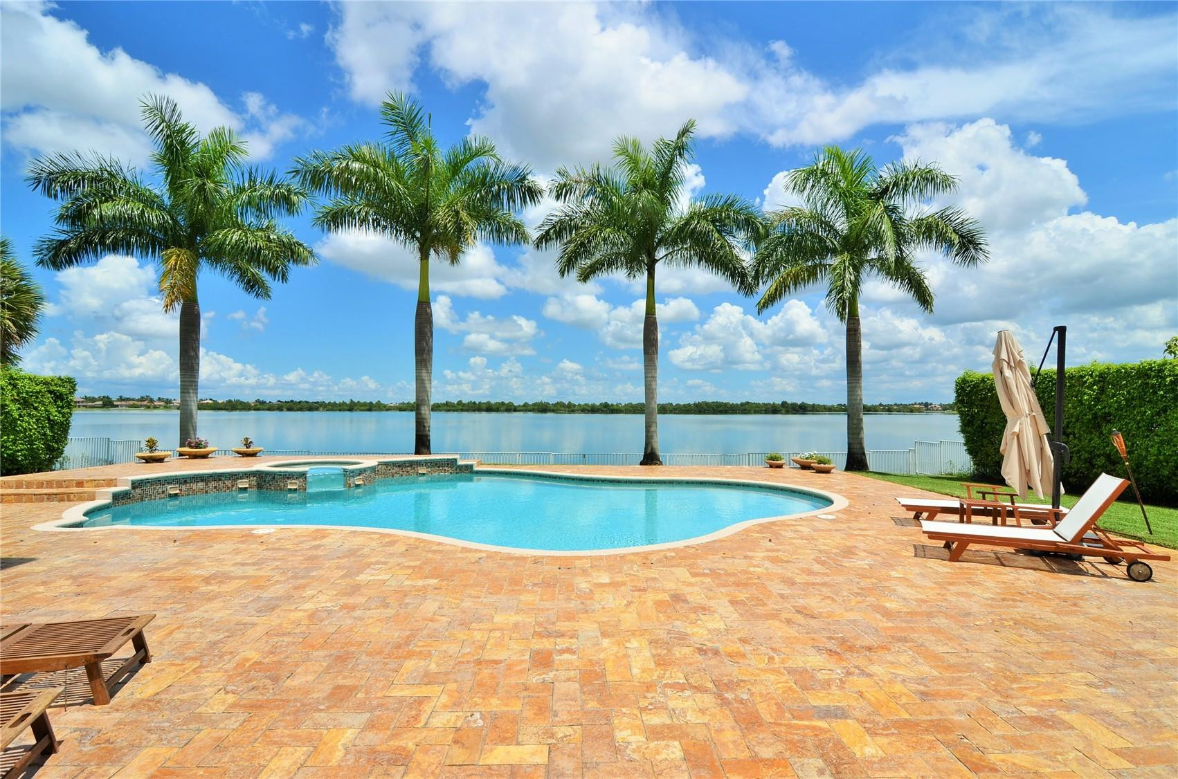 5436 Southwest 191st Terrace Miramar, FL 33029 - Photo 22 of 25 a view of a swimming pool with a table and chairs