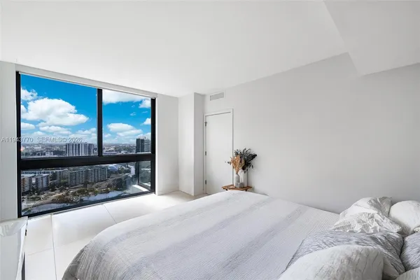 a bedroom with a large bed and a window