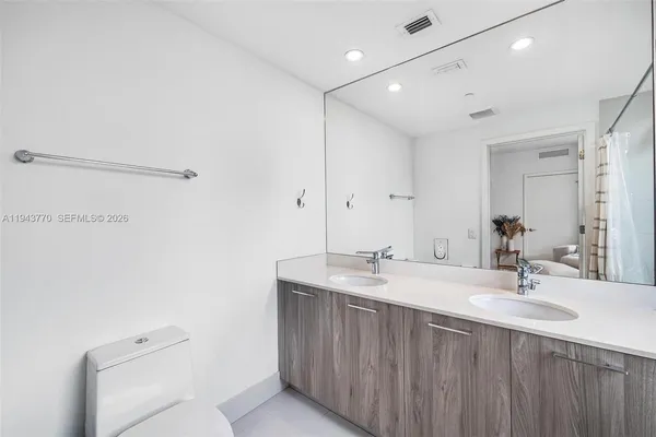 a bathroom with a sink a toilet and mirror
