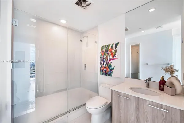 a bathroom with a sink a toilet and shower
