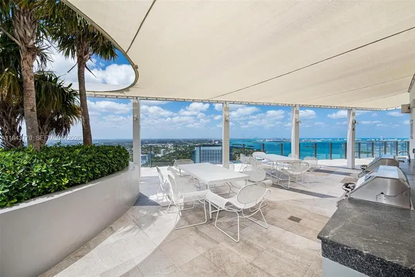 a view of a patio with a table and chairs under an umbrella
