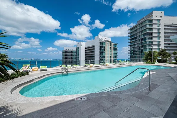 a view of a swimming pool with a lounge chairs in front of house