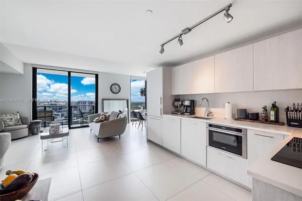 a kitchen with living room and white cabinets