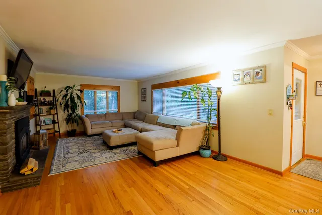 a living room with furniture a flat screen tv and a window