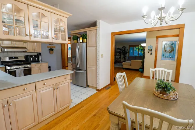 a kitchen with stainless steel appliances granite countertop a table and chairs in it