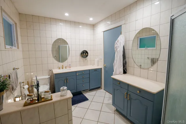 a bathroom with a double vanity sink mirror and shower