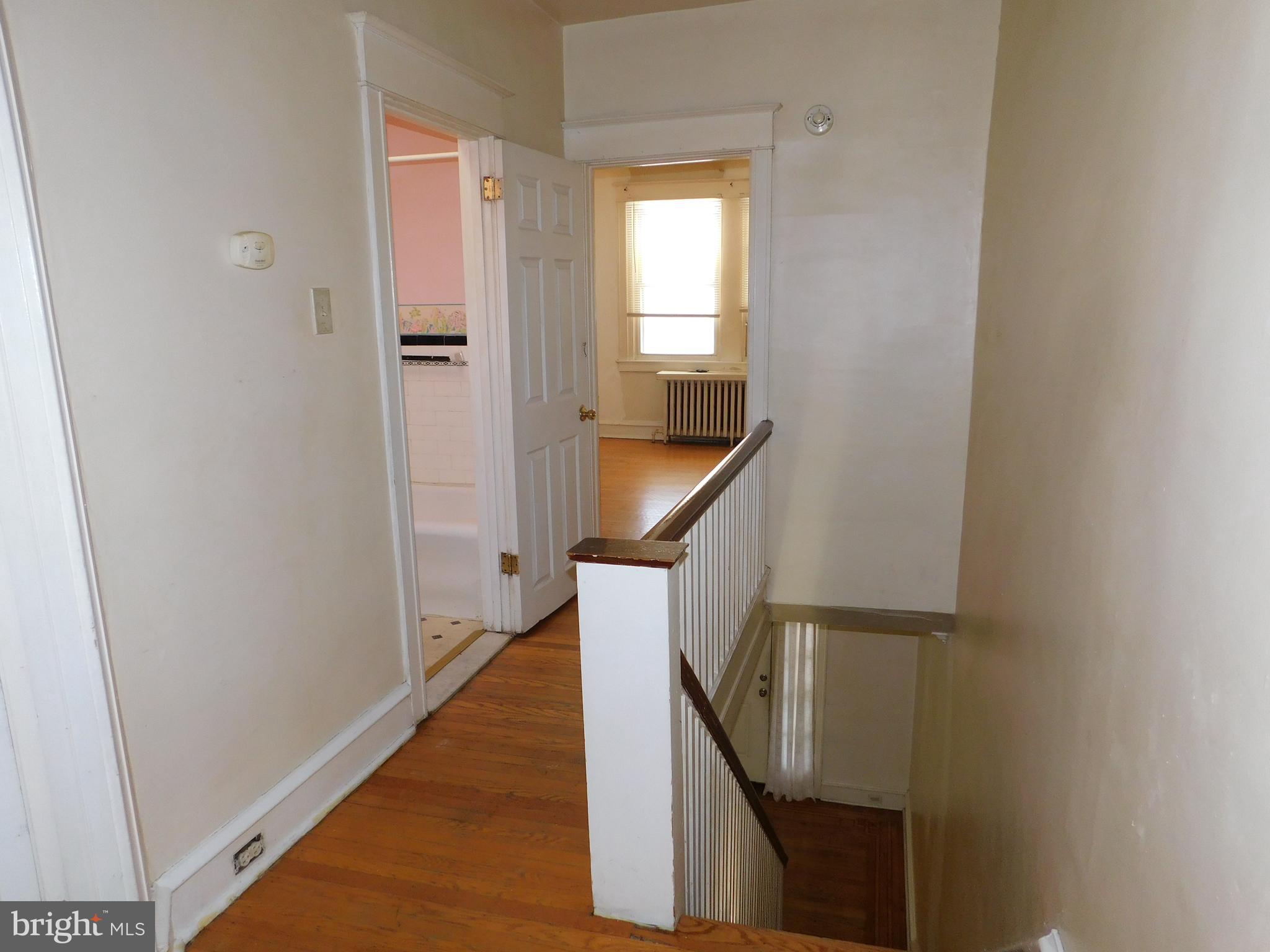 229 Huntley Road Upper Darby, PA 19082 - Photo 9 of 17 a view of a hallway with wooden floor and stairs