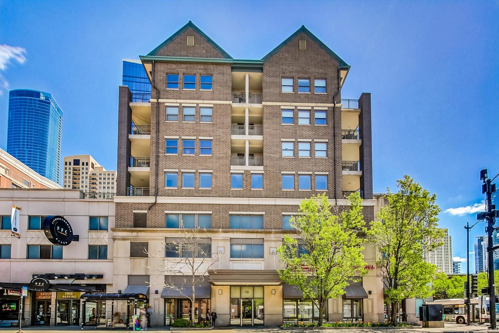 1155 South State Street, Unit C404 Chicago, IL 60605 - Photo 1 of 18 a front view of a residential apartment building with a yard