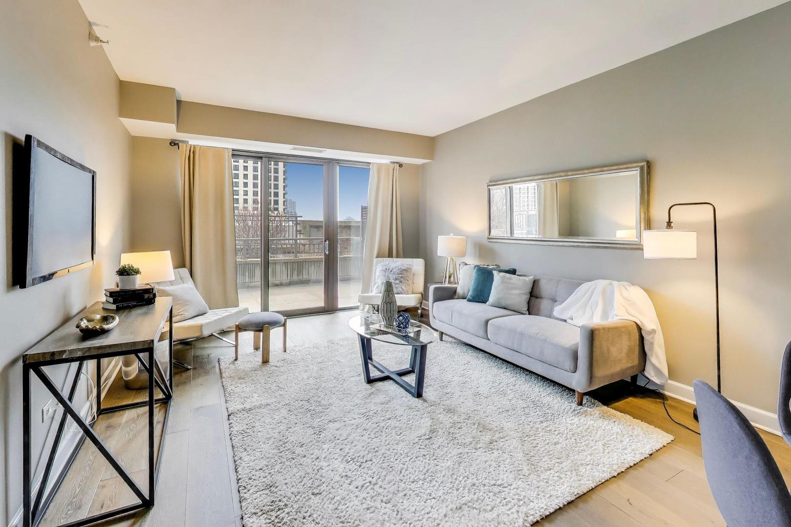 1155 South State Street, Unit C404 Chicago, IL 60605 - Photo 2 of 18 a living room with furniture and a flat screen tv with wooden floor