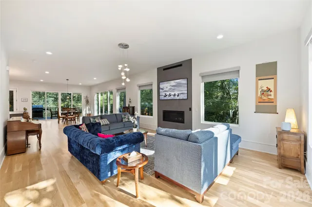 a living room with furniture fireplace and a large window