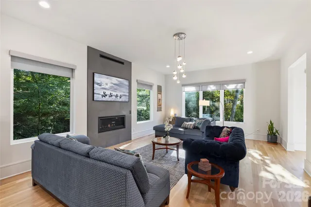 a living room with furniture fireplace and a large window