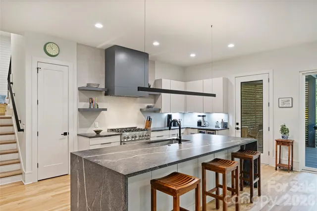 a kitchen with kitchen island granite countertop a sink a counter space and stainless steel appliances