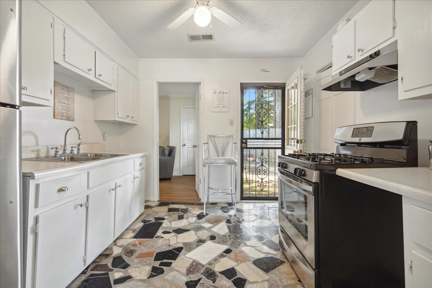 3274 Norton Road Memphis, TN 38109 - Photo 9 of 26 a kitchen with a stove a sink and a refrigerator