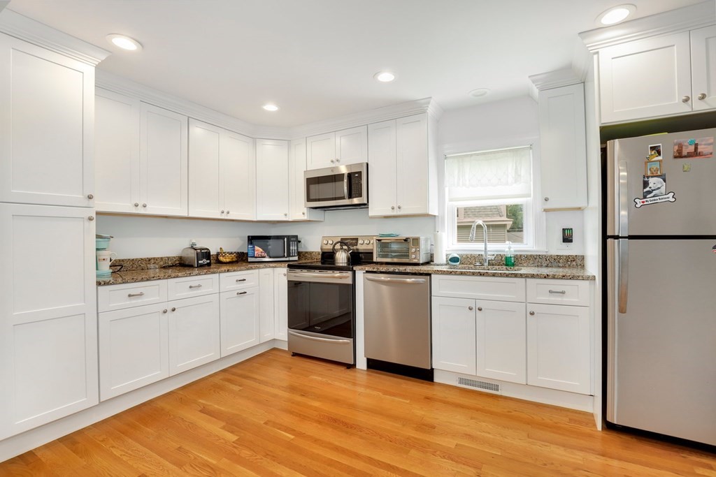 69 R Eastern Avenue Woburn, MA 01801 - Photo 16 of 35 a kitchen with granite countertop white cabinets and white appliances
