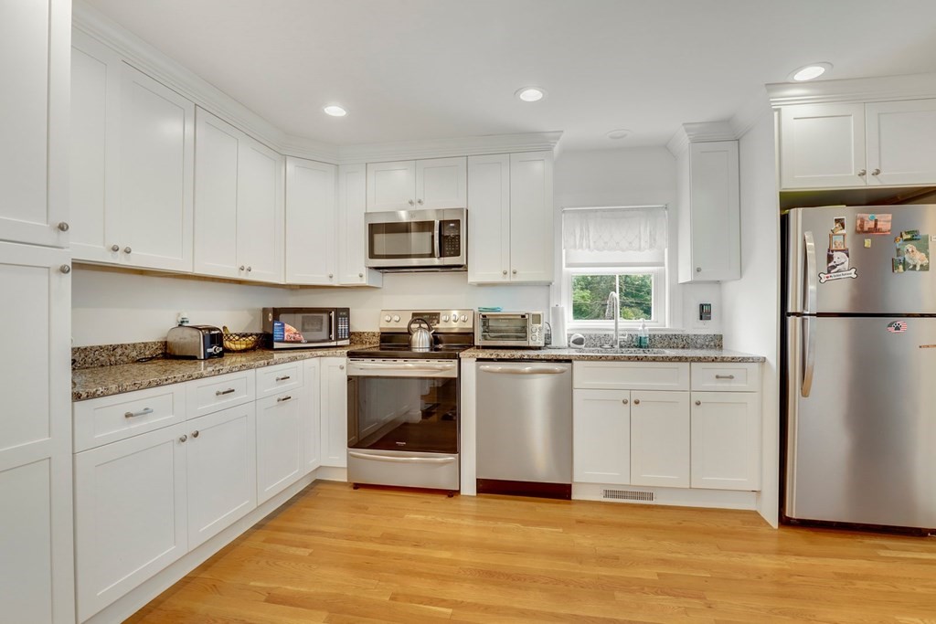 69 R Eastern Avenue Woburn, MA 01801 - Photo 17 of 35 a kitchen with granite countertop white cabinets and white appliances