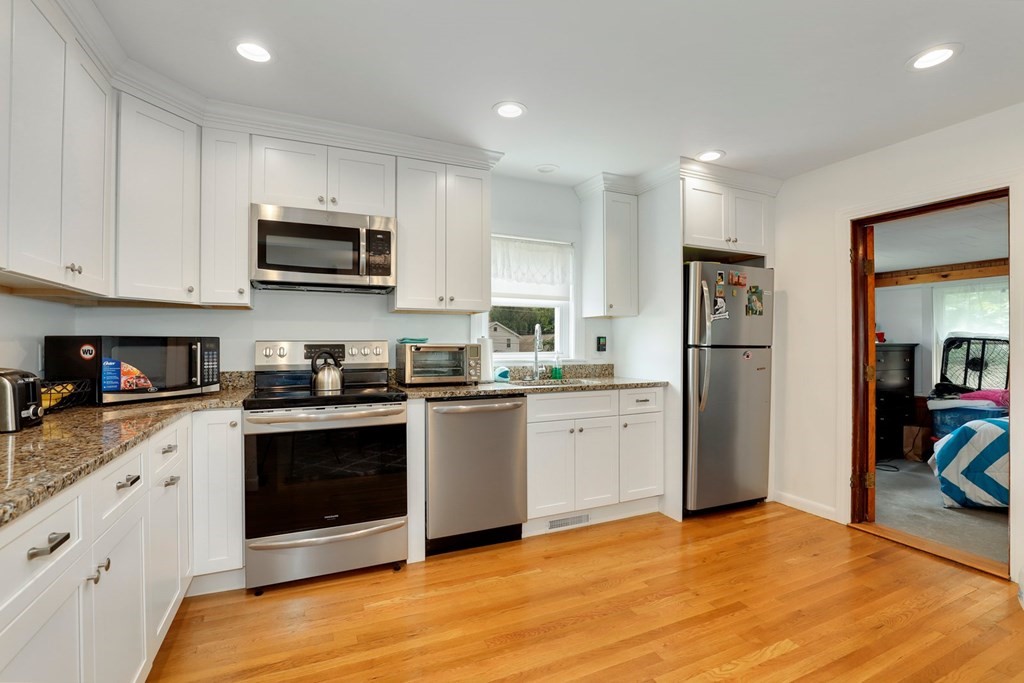 69 R Eastern Avenue Woburn, MA 01801 - Photo 18 of 35 a kitchen with stainless steel appliances granite countertop a stove a refrigerator and a sink