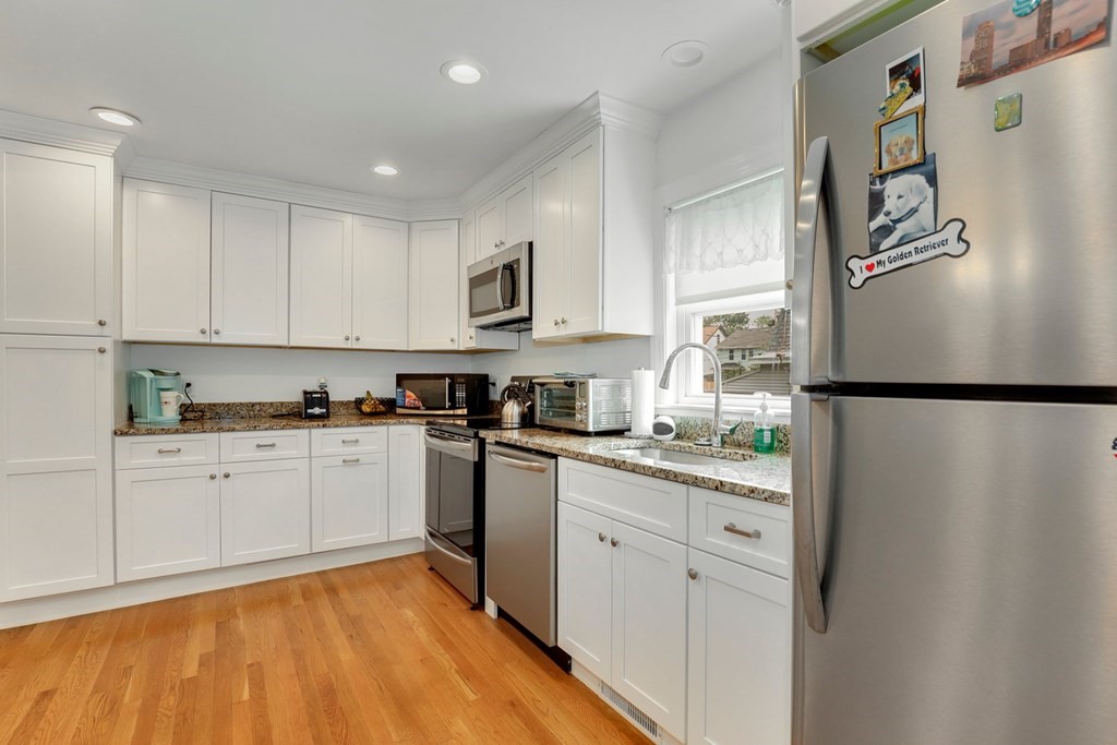 69 R Eastern Avenue Woburn, MA 01801 - Photo 19 of 35 a kitchen with stainless steel appliances granite countertop a refrigerator sink and white cabinets