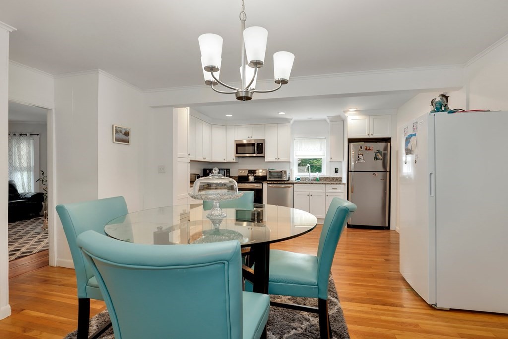 69 R Eastern Avenue Woburn, MA 01801 - Photo 21 of 35 a dining room with granite countertop a table chairs and a refrigerator