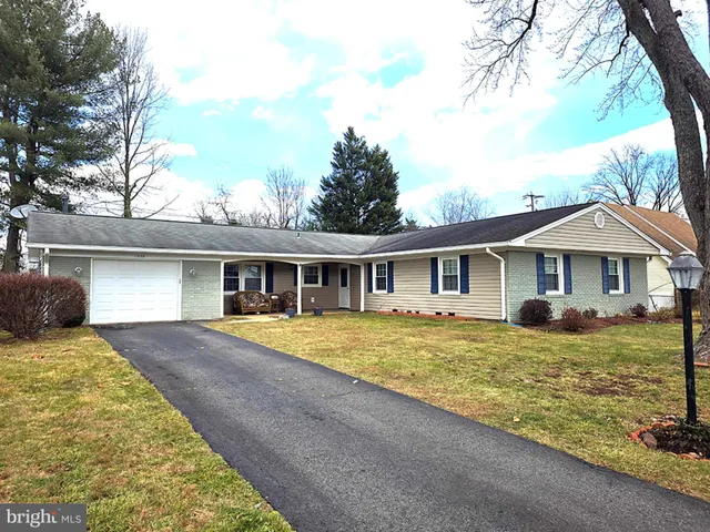 a front view of a house with yard yard and trees