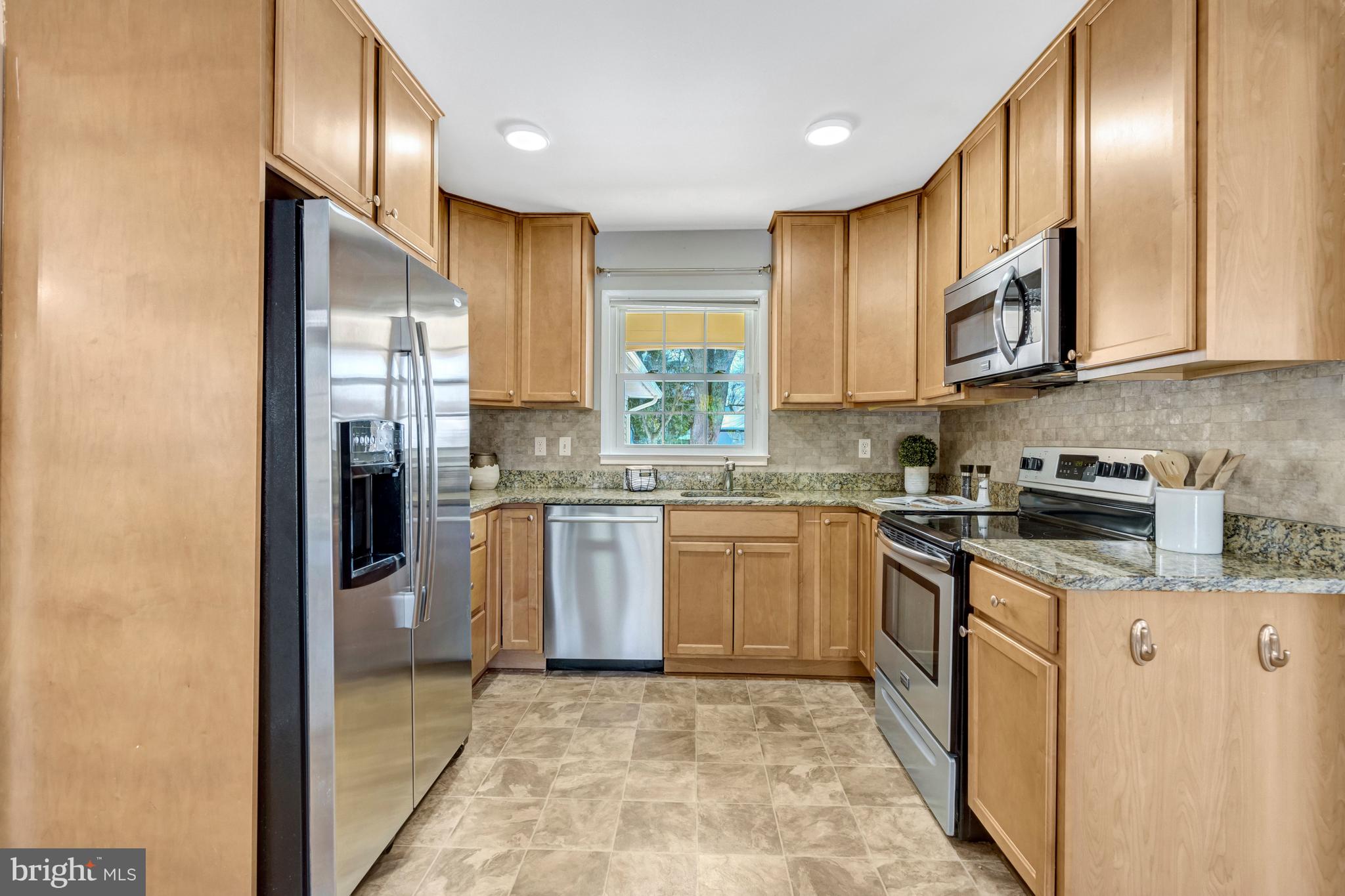 13128 Moss Ranch Lane Fairfax, VA 22033 - Photo 16 of 56 a kitchen with stainless steel appliances granite countertop a refrigerator a stove top oven a sink and dishwasher