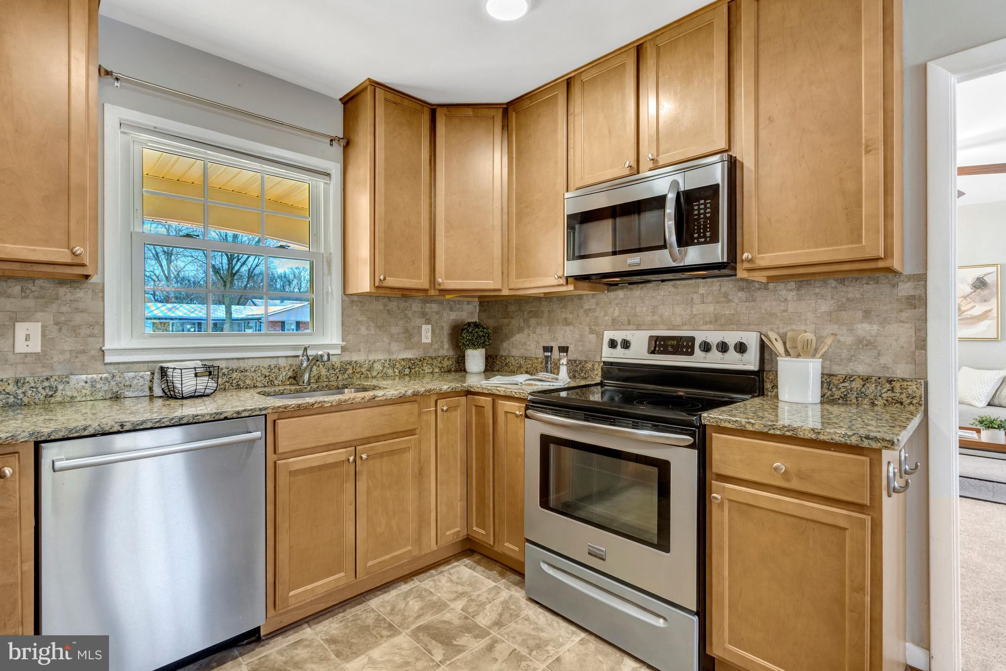 13128 Moss Ranch Lane Fairfax, VA 22033 - Photo 17 of 56 a kitchen with stainless steel appliances granite countertop a stove a sink and a microwave