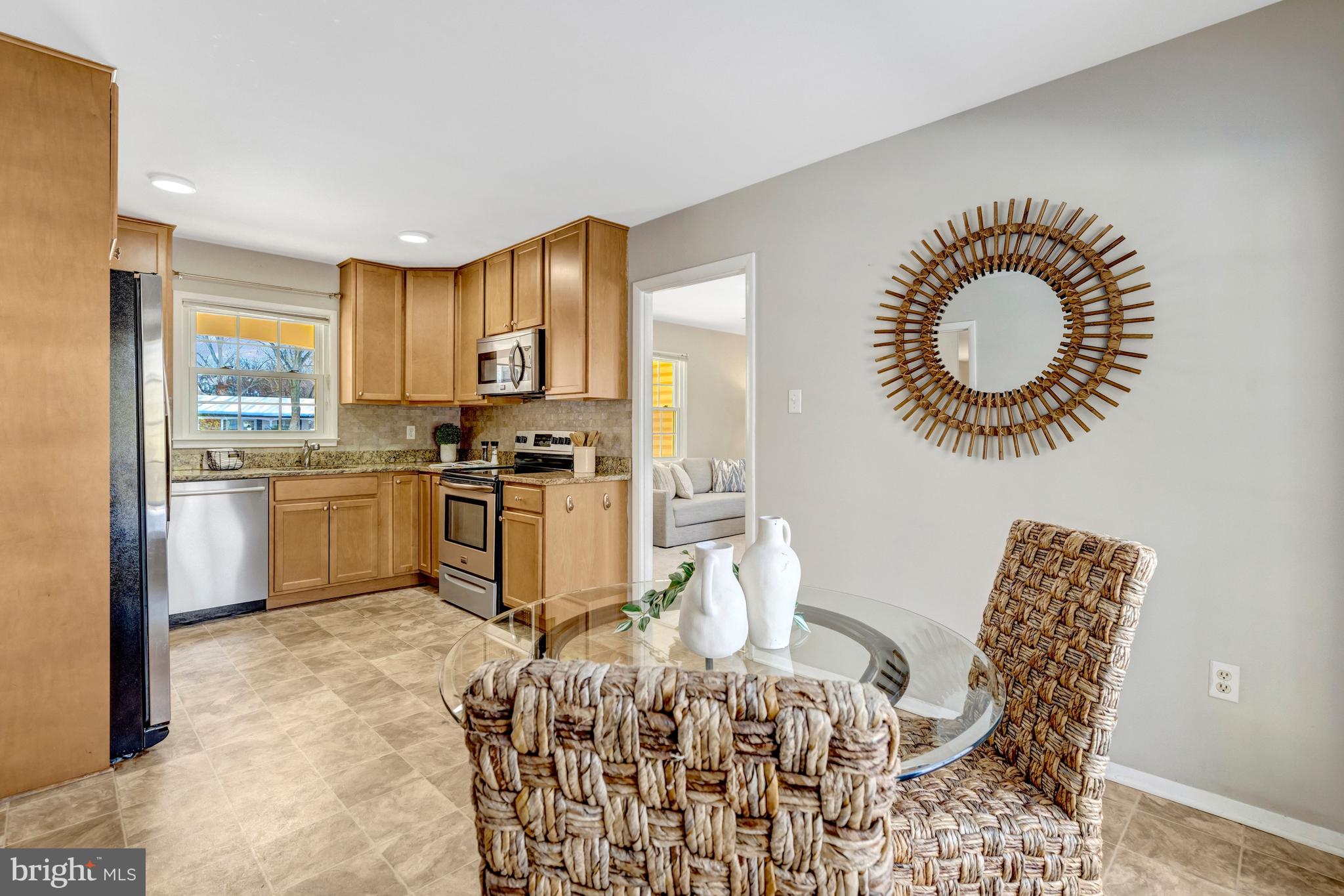13128 Moss Ranch Lane Fairfax, VA 22033 - Photo 19 of 56 a kitchen with granite countertop a stove a sink a dining table and chairs