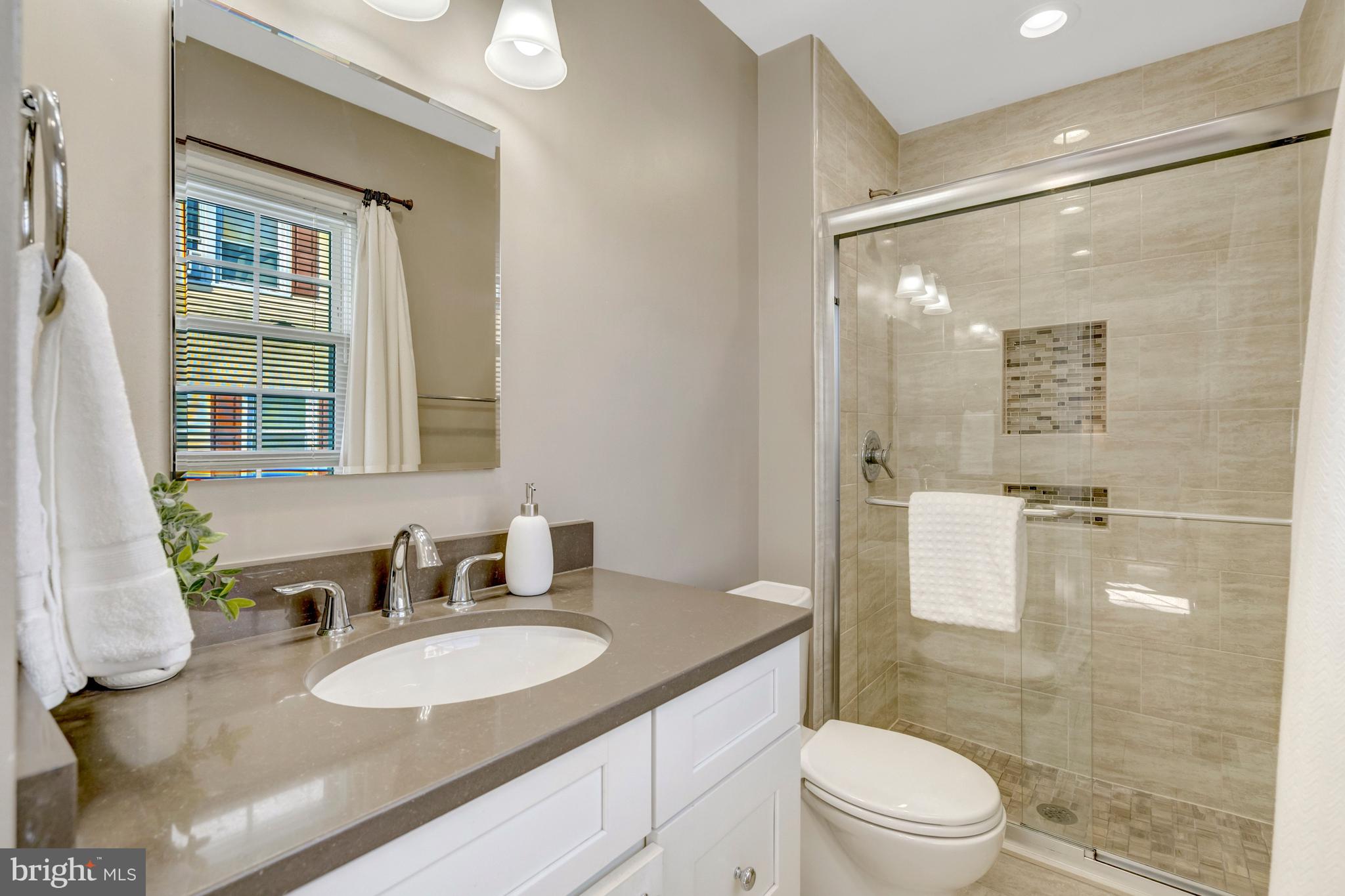 13128 Moss Ranch Lane Fairfax, VA 22033 - Photo 35 of 56 a bathroom with a granite countertop sink a toilet a mirror and shower