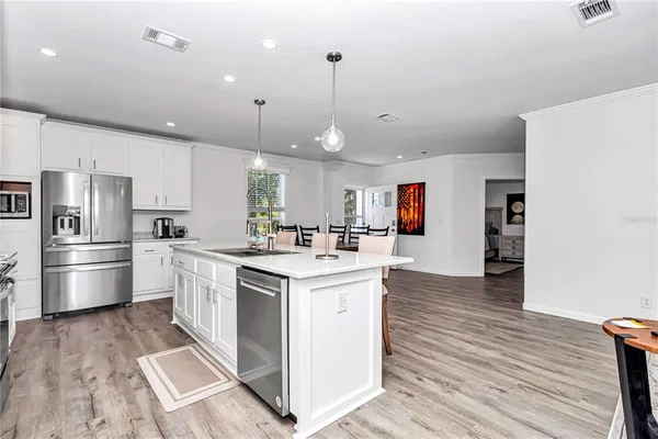 a kitchen with stainless steel appliances white cabinets and a refrigerator