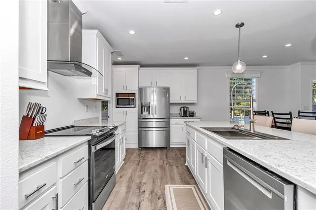 a kitchen with granite countertop a refrigerator and a sink