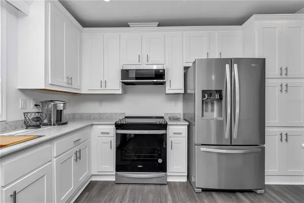 a kitchen with granite countertop white cabinets and a window