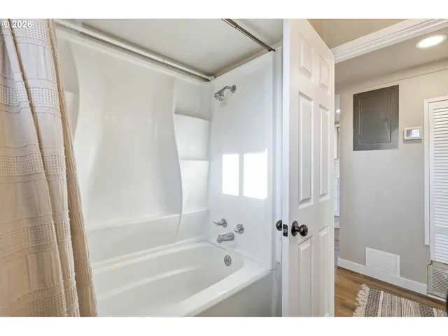 a bathroom with a bathtub shower and a sink
