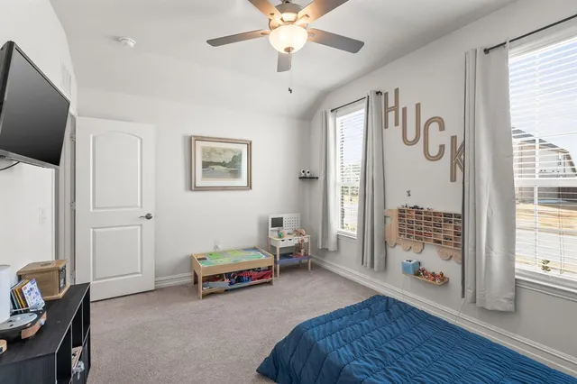a spacious bedroom with a bed and a chandelier