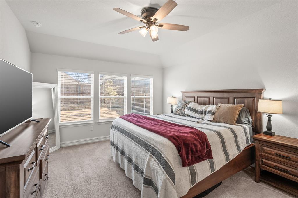 2920 Arlo Road Aubrey, TX 76227 - Photo 18 of 31 a bed room with a bed and a chandelier