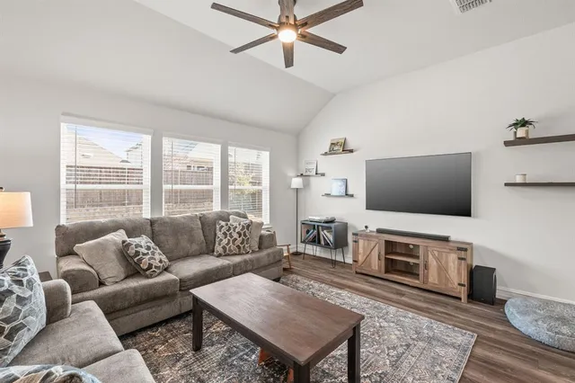 a living room with furniture a flat screen tv and a fireplace