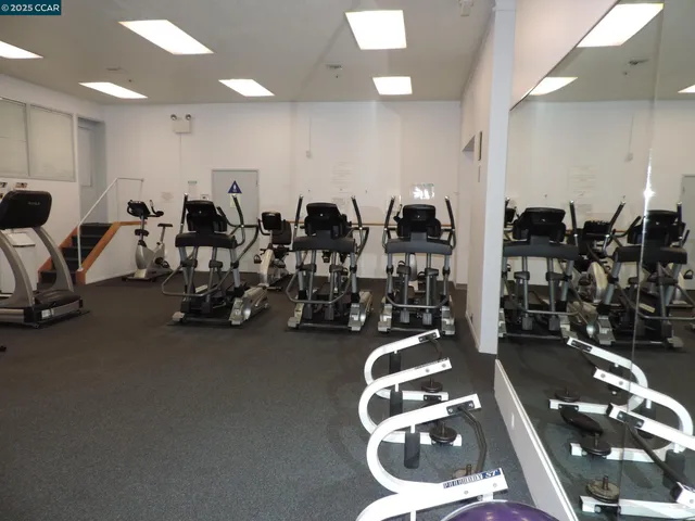 a room with gym equipment and large mirror