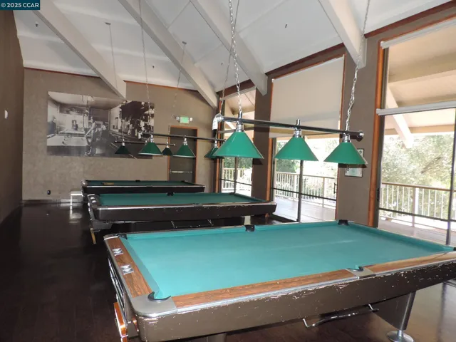 a room with pool table and windows
