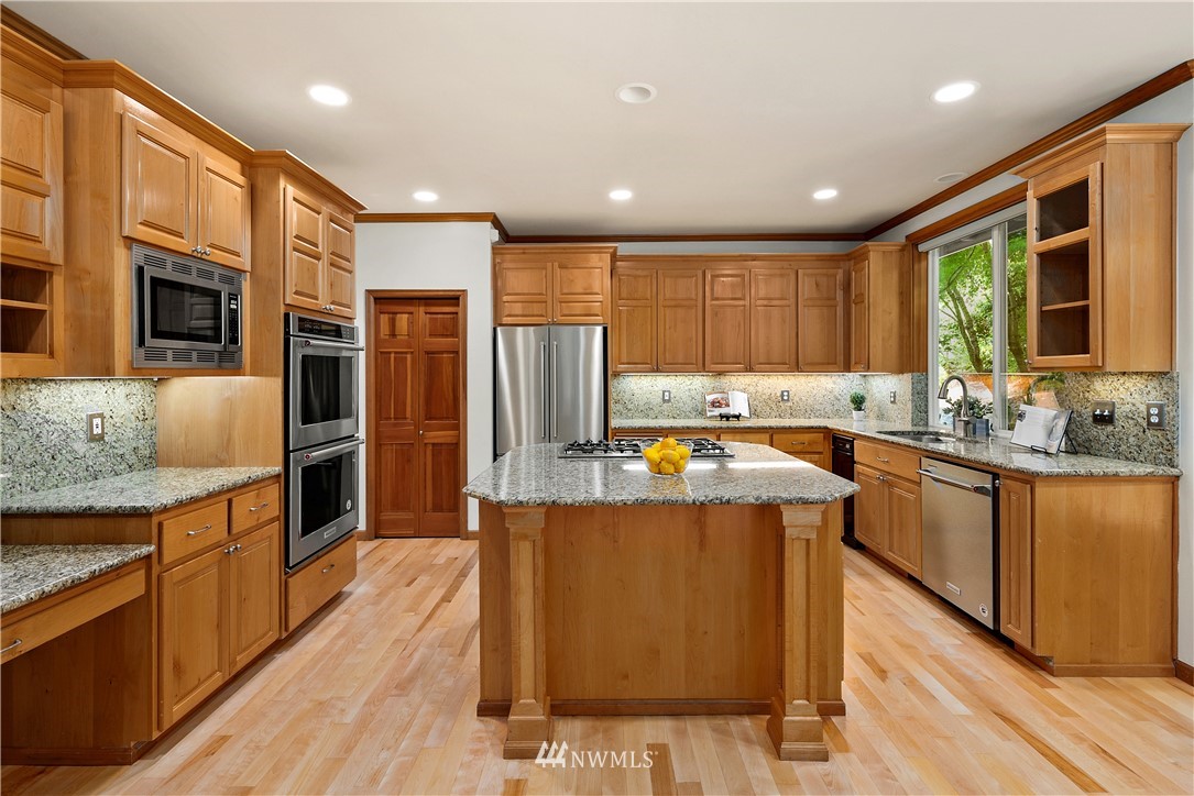 4729 176th Street Southeast Bothell, WA 98012 - Photo 11 of 40 a kitchen with stainless steel appliances kitchen island granite countertop a stove refrigerator and cabinets