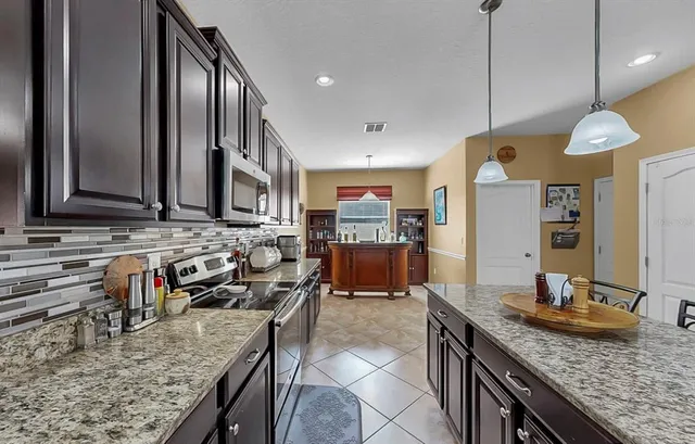 a living room with stainless steel appliances granite countertop furniture and a window